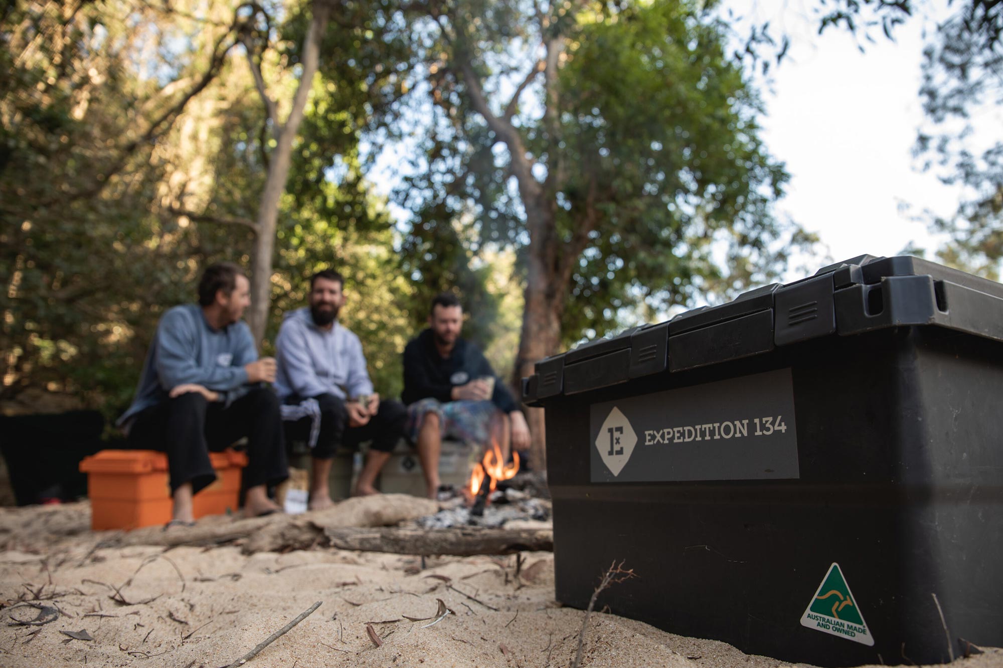 A guide to finding the perfect camping storage box. A group of friends enjoying camping by a fire on the Wenlock River in FNQ with an Expedition134 camp box